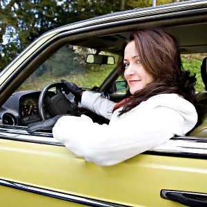 Young woman in a post-war classic car Young woman in a post-war classic car