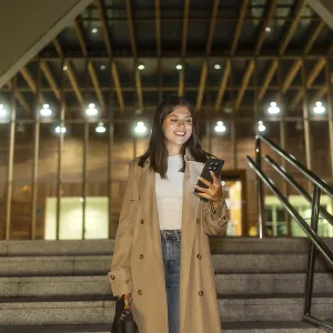 Young woman smiling while checking her smartphone Young woman smiling while checking her smartphone