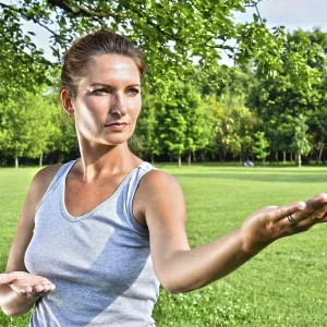 Young woman during tai chi exercise in the park Young woman during tai chi exercise in the park
