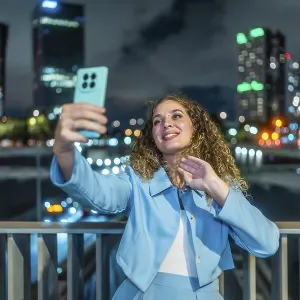 Young Woman Taking a Selfie on City Bridge at Night Print