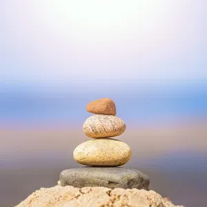 Zen balanced small pile of stacked stones on the beach in summer