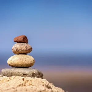 Zen balanced small pile of stacked stones on the beach in summer