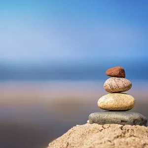 Zen balanced small pile of stacked stones on the beach in summer