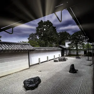 Zen garden with textured sand patterns and rocks surrounded by traditional Japanese architecture Zen garden with textured sand patterns and rocks surrounded by traditional Japanese architecture