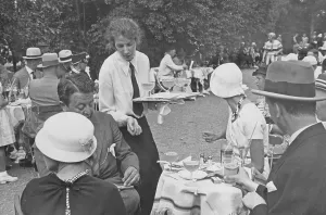 1930s open-air cafe. It's full of people eating and drinking