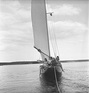 1940s boating. Four young women are on board a fashionable sailing boat that is being towed