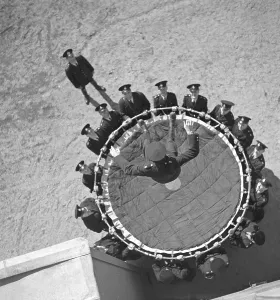 In the 1940s. A brave fireman lands in a life saving sheet. A device invented in 1887, and was until the 1980s used to save people by letting them jump from the upper floors of a burning buildings into the net, usually to the ground level