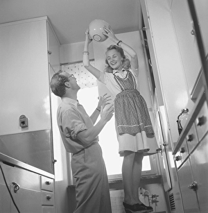 In the 1940s. A couple looking happy when playing around in the kitchen