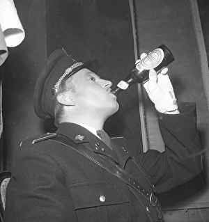 The 1940s. A man dressed in uniform drinks beer from a bottle made by the Danish brewery Tuborg