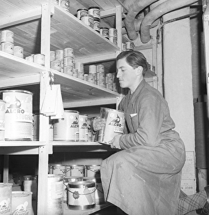 In the 1940s. A man seen arranging buckets of paint in a storeroom
