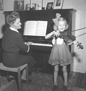 In the 1940s. A mother and her daughter play music together at home