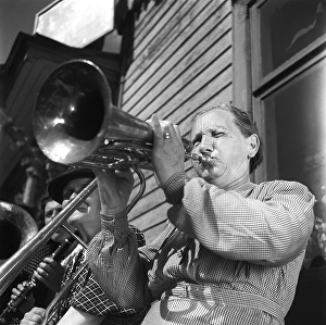 1940s musical woman. An elderly lady in an all-women band is playing a horn instrument