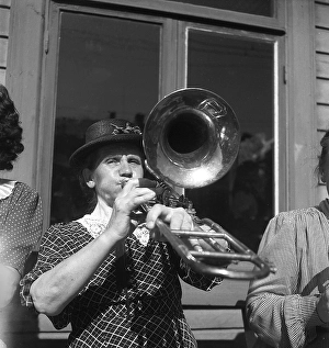 1940s musical woman. A woman in an all-women band is playing the trombone