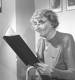1940s woman with glasses. An elderly lady with her glasses on her nose tip