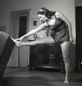 In the 1940s. A young woman in her livingroom while exercising