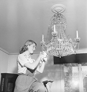 In the 1940s. A young woman stands on a ladder polishing the prisms in a crystal chandelier hanging from the ceiling. A time-consuming job and to achieve a good result, you have to polish each glass prism separately with the polishing cloth
