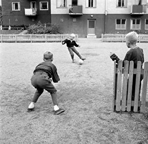 1950s boys playing soccer. Children playing football on the open space in the living area
