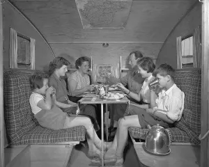 1950s camping. A family is enjoying their holiday and the practial camping life in their caravan