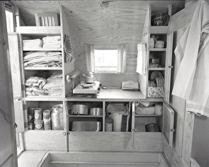 1950s camping. A family is enjoying their holiday and the practial camping life in their caravan