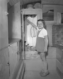 1950s camping. A family is enjoying their holiday and the practial camping life in their caravan