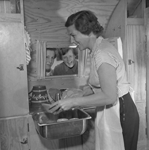 1950s camping. A family is enjoying their holiday and the practial camping life in their caravan