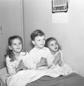 In the 1950s. Three children in bed at bedtime saying their evening prayers together. Sweden 1959. Kristoffersson ref CL23-9