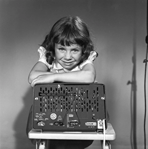 In the 1950s. A girl with a Philips radio set with the backside of the radio visible where the sockets for external