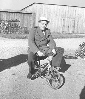 1950s man on a bicycle. Actor Hampe Faustman is riding a childrens bicycle