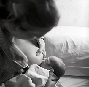 1950s mother nursing her baby. A young woman breastfeeding her baby at home. Sweden 1951 Neg CV/24