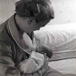 1950s mother nursing her baby. A young woman breastfeeding her baby at home. Sweden 1951 Neg CV/24