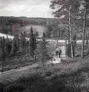 1950s outdoor life. A couple is out in the nature and is walking along a small road enjoying the sunny day