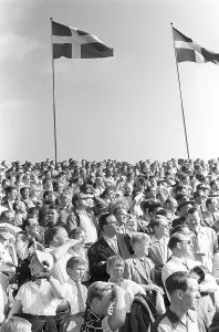 In the 1950s. The stand is full of people watching an ongoing football match at an outdoor stadium in Stockholm Sweden 1953. Kristoffersson ref 1-41-1