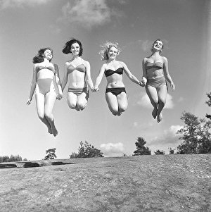 1950s summer. A group of young women in their bikinis are happy on this summer's day