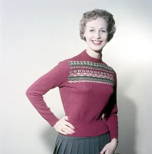 In the 1950s. A woman modelling a 1950s red knitted sweater with pattern