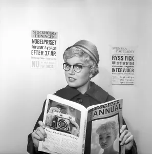 In the 1950s. A woman reads from the 1958 edition of Photography annual