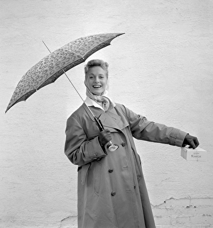 1950s woman with umbrella. A young woman is holding an umbrella on a rainy day