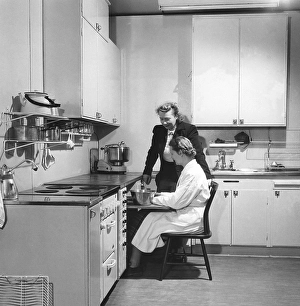 In the 1950s. Two women are seen in a typical 1950s kitchen with the details of the interior