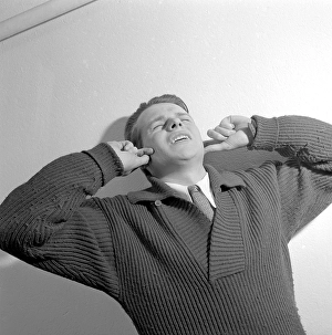 In the 1950s. A young man holds his hands over his ears