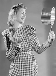 In the 1950s. A young woman looks happy with the cleaning result she made with the metal wool