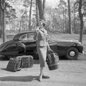 In the 1950s. A young woman in a matching outfit of jacket and skirt