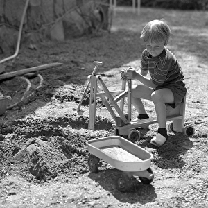 In the 1960s. A boy is playing with a toy excavator