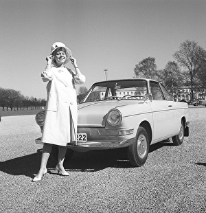 In the 1960s. The fashionable dressed woman stands in front of her car