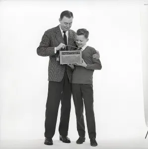 In the 1960s. Father and son with a radio