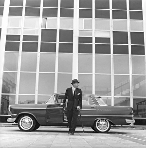 In the 1960s. A man is seen standing at his car