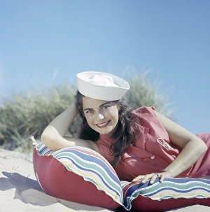 In the 1960s. A young woman on a mattress a sunny day on the beach