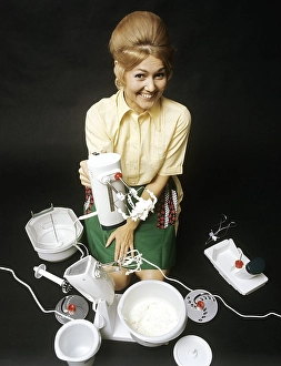 In the 1960s. A young woman pictured with an electric mixer having whipped cream