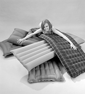 1960s. A young woman wearing a bikini, in a photographers studio with different types and brands of air mattresses. A picture taken to illustrate the new ones available in different shapes and colors to use the upcoming summer. Sweden 1967