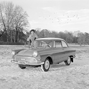 In the 1960s. A young woman in the winter with her brand new car