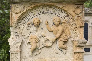 2 angel figures in sandstone on a historic gravestone