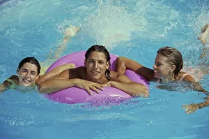 3 young woman in the water, 1 woman with swimming ring